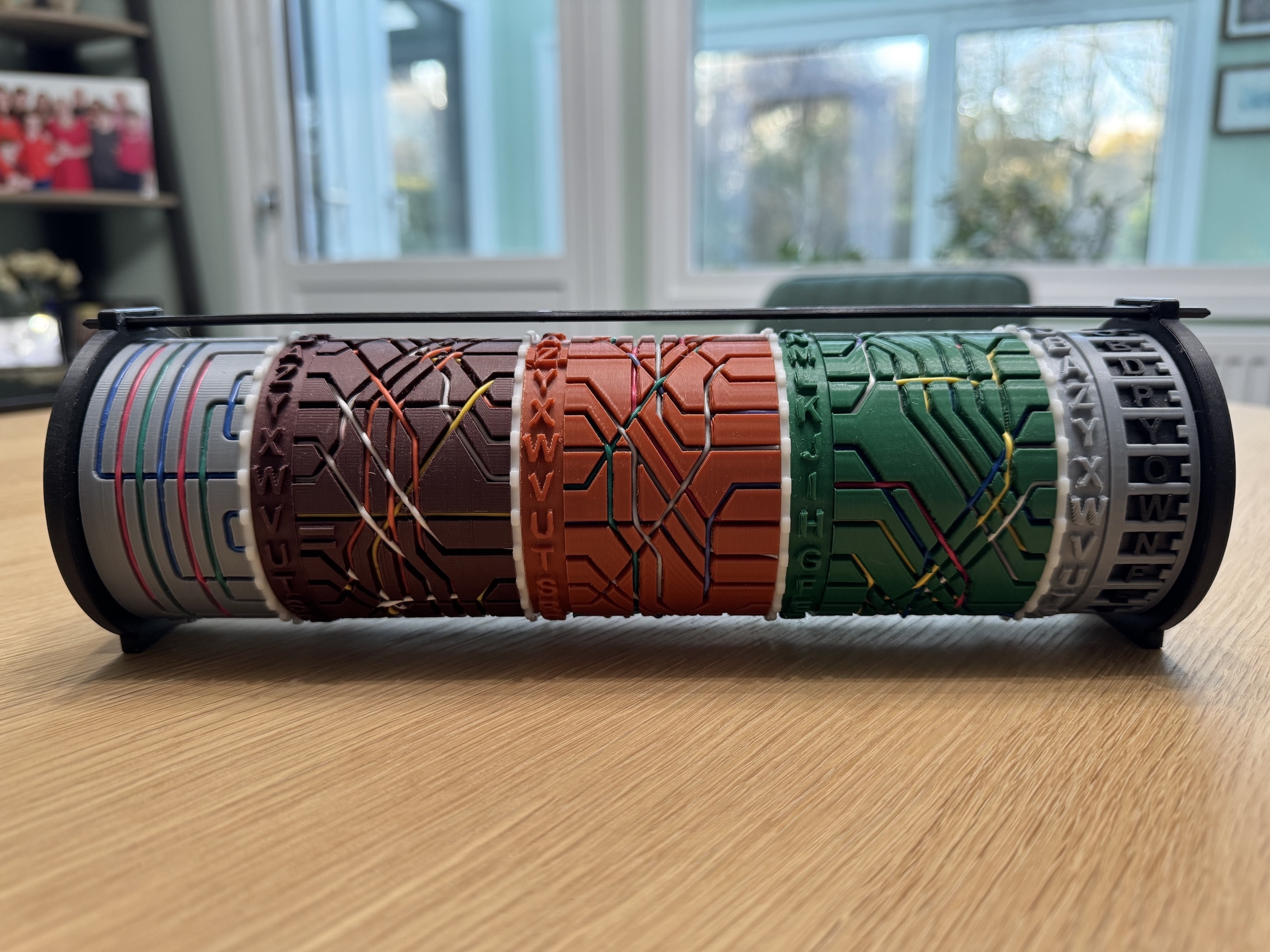 Image of a 3d printed enigma with 3 rotors.  Looks like a Pringles tube with rotatable parts and wiring showing the encryption path.