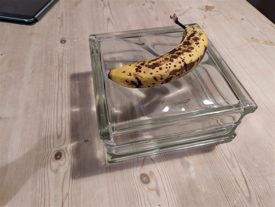 A single cleaned glass brick with a banana on top for sale