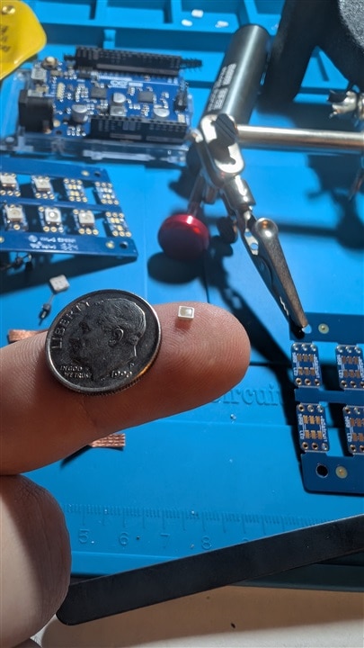 LED on finger with dime for scale