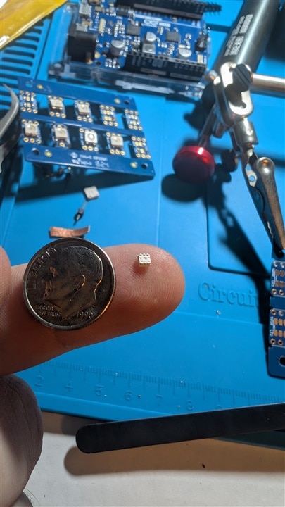LED on finger with dime for scale