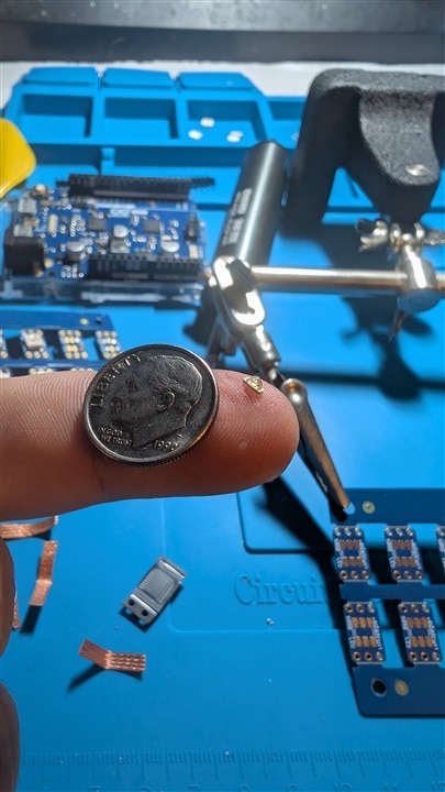 LED on finger with dime for scale