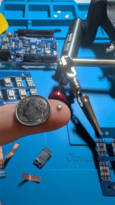 LED on finger with dime for scale