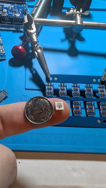 LED on finger with dime for scale